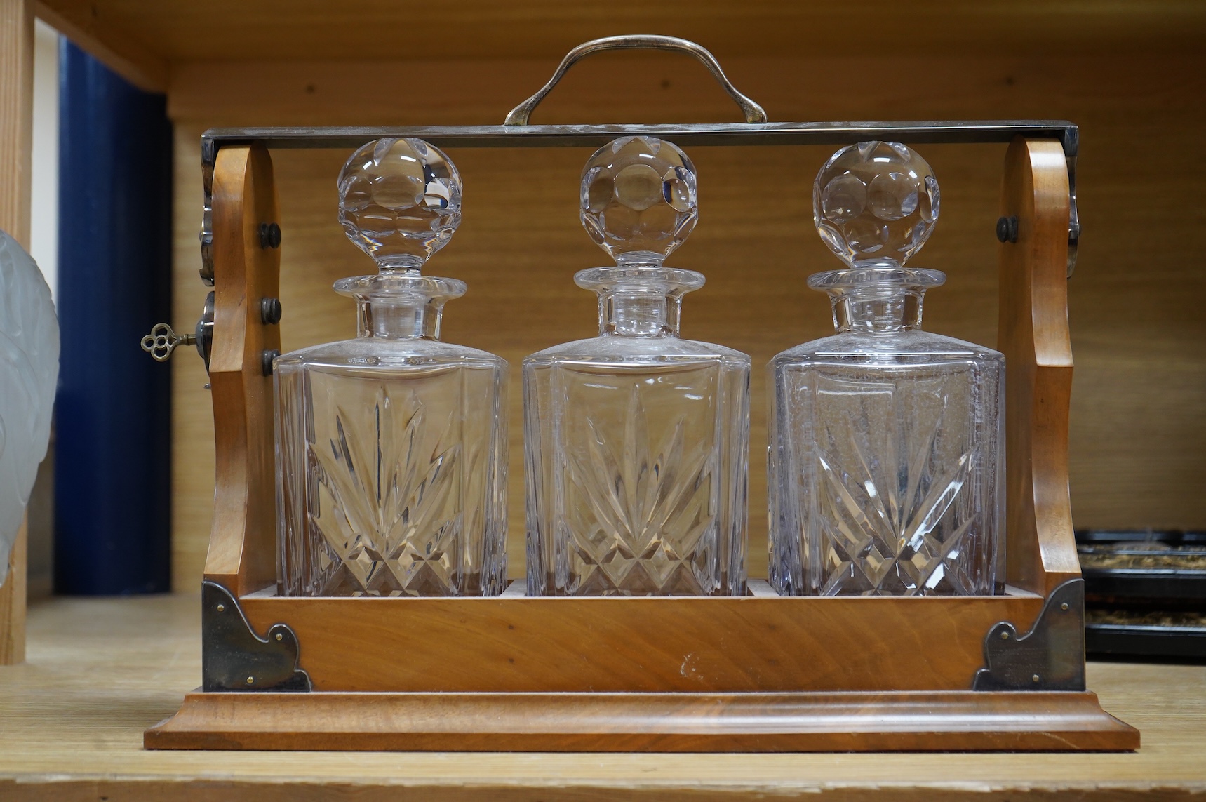 A walnut three-decanter tantalus, 41cm